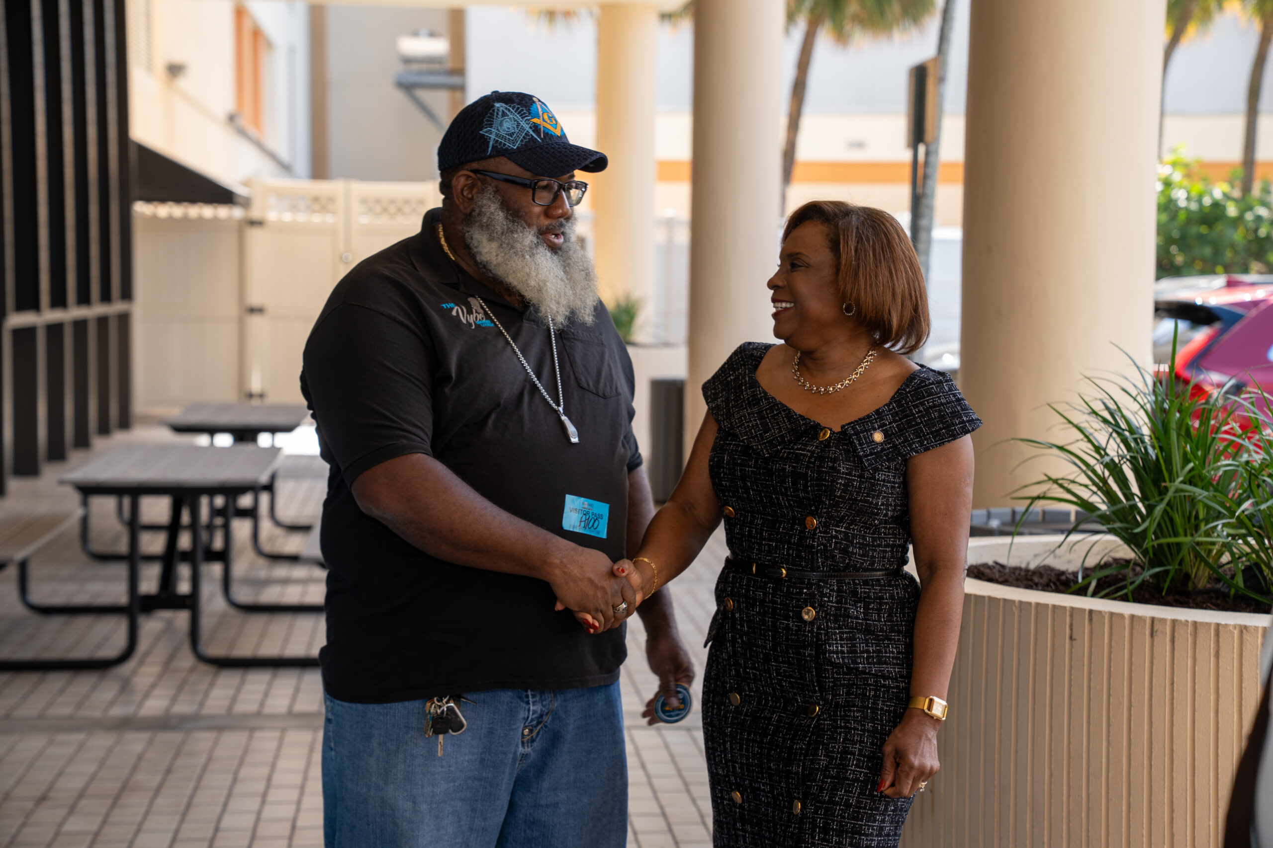 Abbey Ajayi shaking hands with a local residents. A representation of community engagement as the Broward Tax Collectors office returns 17 million.