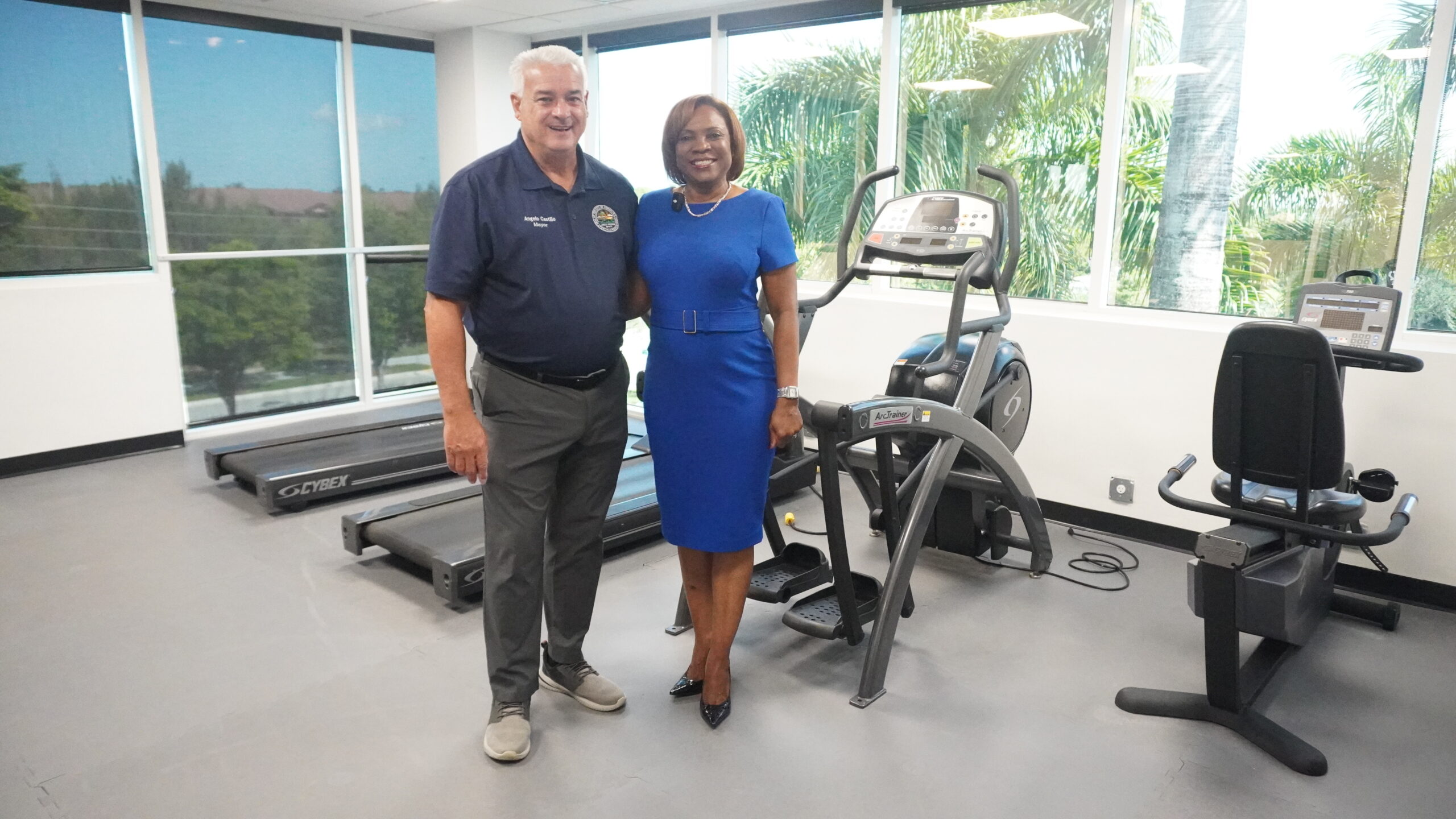 Mayor Angelo Castillo and Broward County Tax Collector Abbey Ajayi beside donated fitness equipment at the Carl Shechter Senior Center